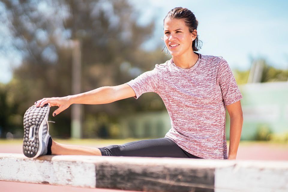 Natasha estirando en una pista de atletismo